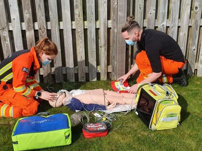 Paramedic Sophie And Dr Jono Training on a manikin, surrounded by kit bags Paramedic Sophie And Dr Jono Training on a manikin, surrounded by kit bags