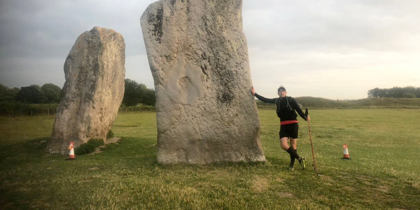 A supporter wearing black sports gear who is stood next to the Avebury Stones after taking part in the Race to the Stones event. A supporter wearing black sports gear who is stood next to the Avebury Stones after taking part in the Race to the Stones event.