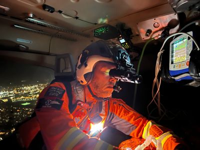 Paramedic Paul Rock wearing flight helmet and night vision goggles Treating a Patient whilst flying in the Wiltshire Air Ambulance At Night Paramedic Paul Rock wearing flight helmet and night vision goggles Treating a Patient whilst flying in the Wiltshire Air Ambulance At Night