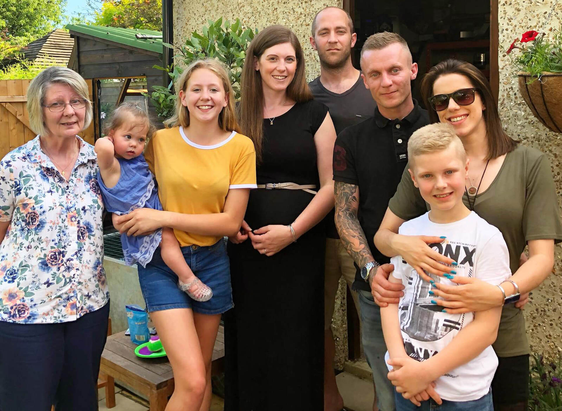 A group of family photographed in a garden