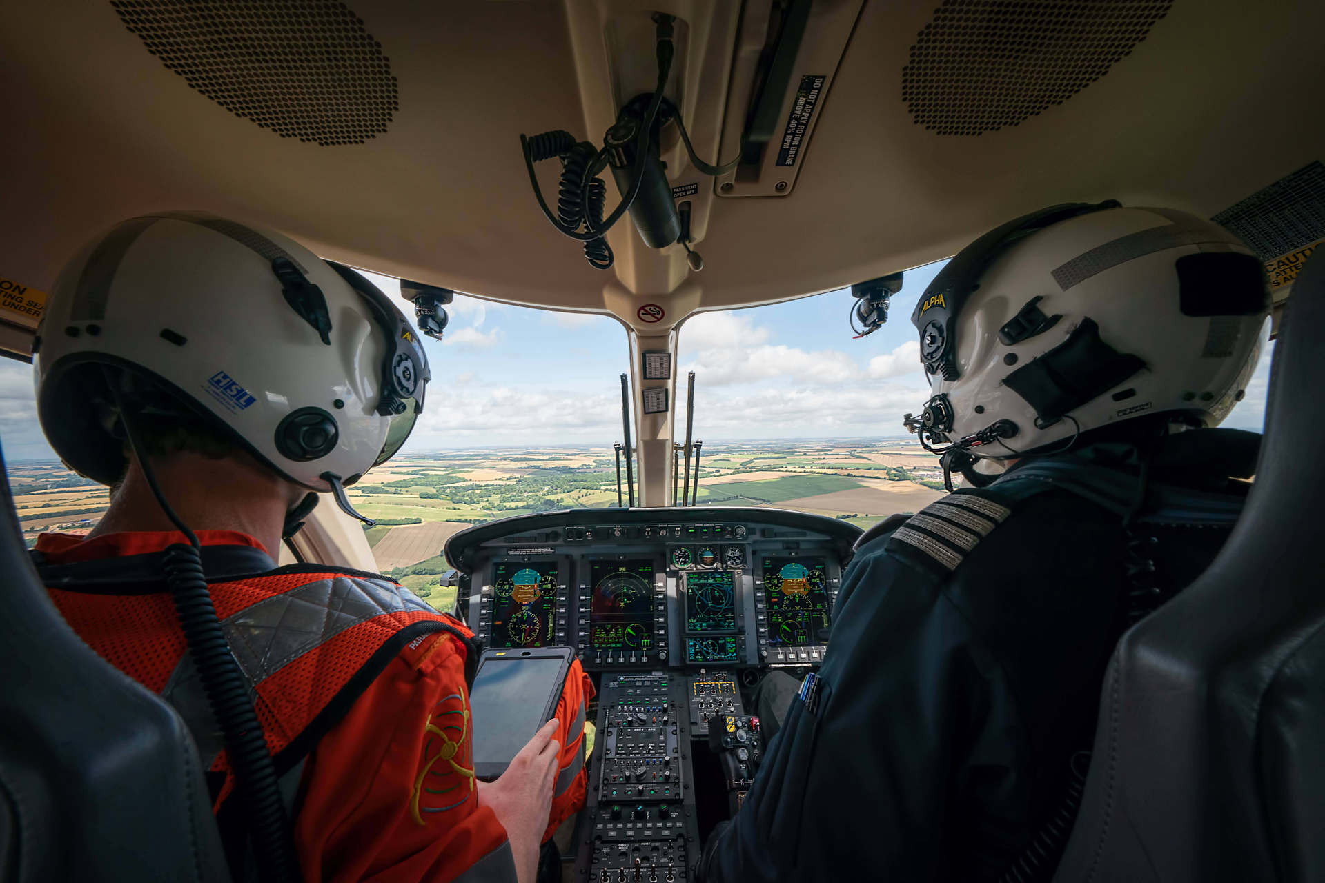 A paramedic and pilot sat in the cockpit of the helicopter whilst in flight. A paramedic and pilot sat in the cockpit of the helicopter whilst in flight.