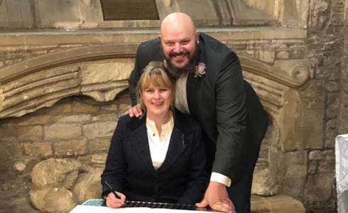 A happy couple signing a register on their wedding day