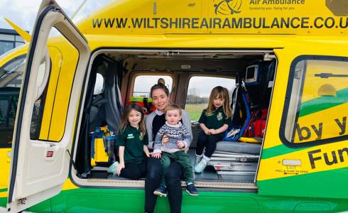 A family sat inside the Bell-429 helicopter on its helipad.