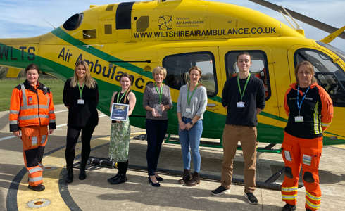 A group photo of charity team members and two paramedics accepting the Pride of Wiltshire Award in 2022.