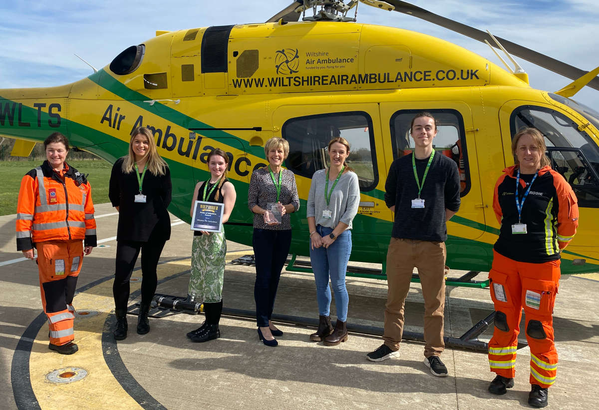 A group photo of charity team members and two paramedics accepting the Pride of Wiltshire Award in 2022.