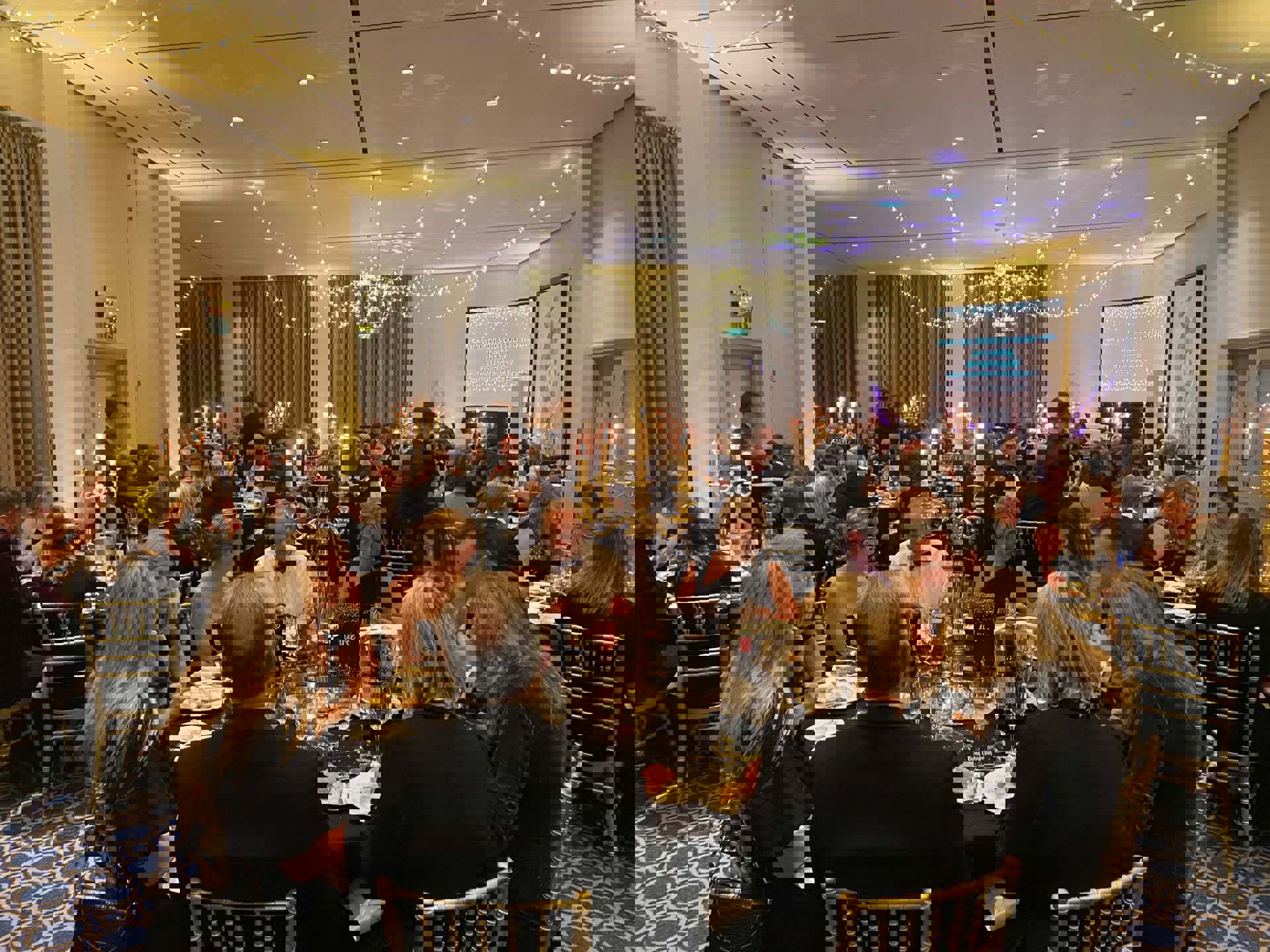 Black and gold themed charity ball. Groups of people wearing smart clothing, sitting on gold chairs around round tables Black and gold themed charity ball. Groups of people wearing smart clothing, sitting on gold chairs around round tables