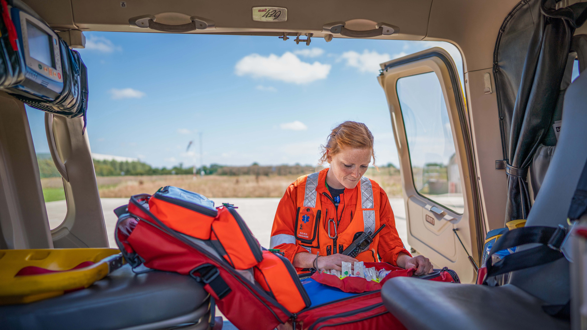 A paramedic looking in a kit bag, which is inside a helicopter A paramedic looking in a kit bag, which is inside a helicopter