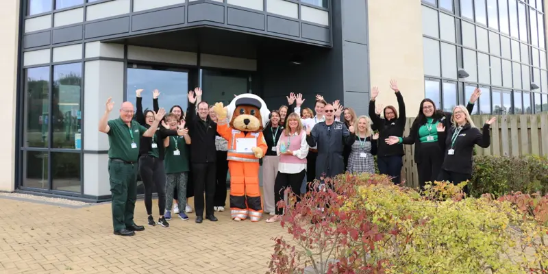 The charity team and mascot celebrating outside the airbase holding a vase award and certificate The charity team and mascot celebrating outside the airbase holding a vase award and certificate