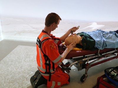 Critical care paramedic Craig Wilkins in a training scenario in the charity's simulation room using a mannequin and medical equipment.