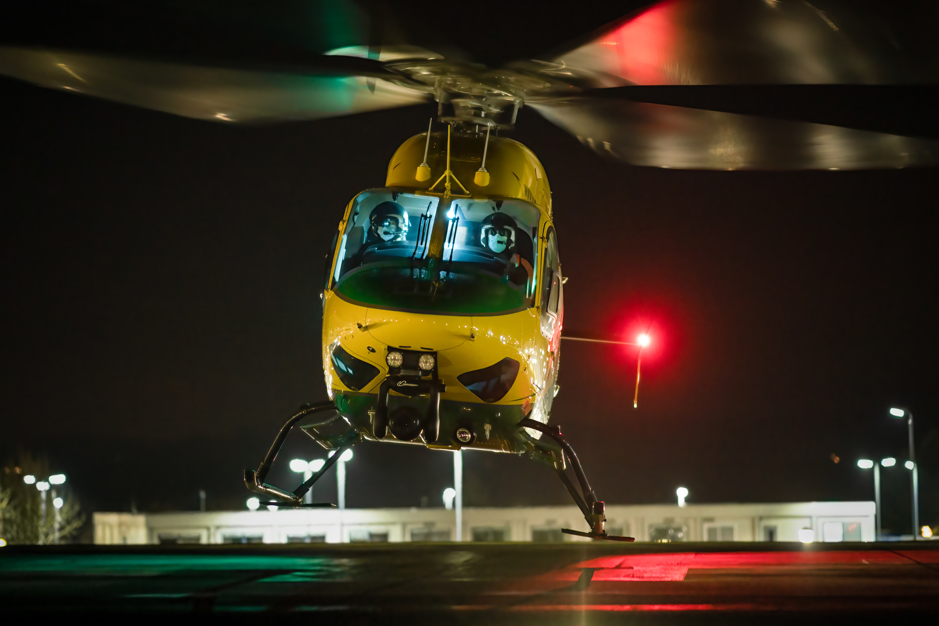 Wiltshire Air Ambulance helicopter lifting from a helipad at night