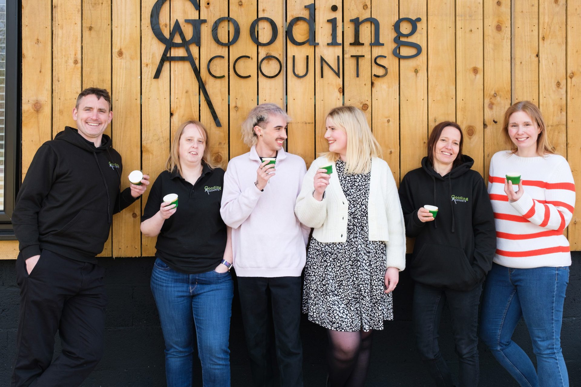 6 people standing in front of a Gooding Accounts sign 6 people standing in front of a Gooding Accounts sign