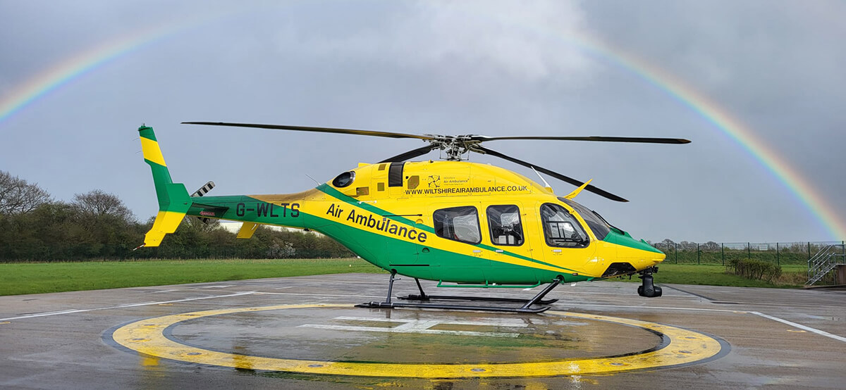 WAA helicopter on the charity's helipad under a rainbow