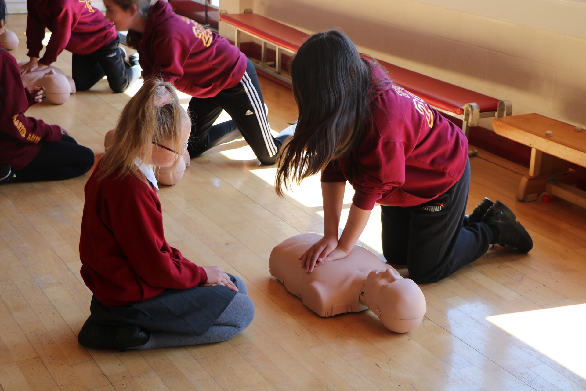 School children practicing CPR on a manekin School children practicing CPR on a manekin