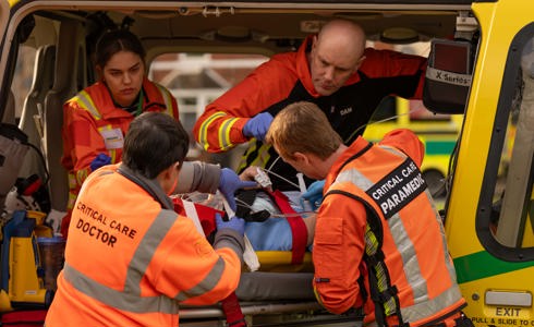 A team of critical care paramedics and doctors working on a patient on a stretcher in the back of the charity's helicopter