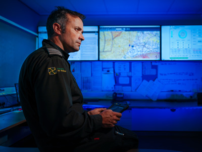 Pilot Matt looking at screens in Wiltshire Air Ambulance's ops room with ipad in hand Pilot Matt looking at screens in Wiltshire Air Ambulance's ops room with ipad in hand