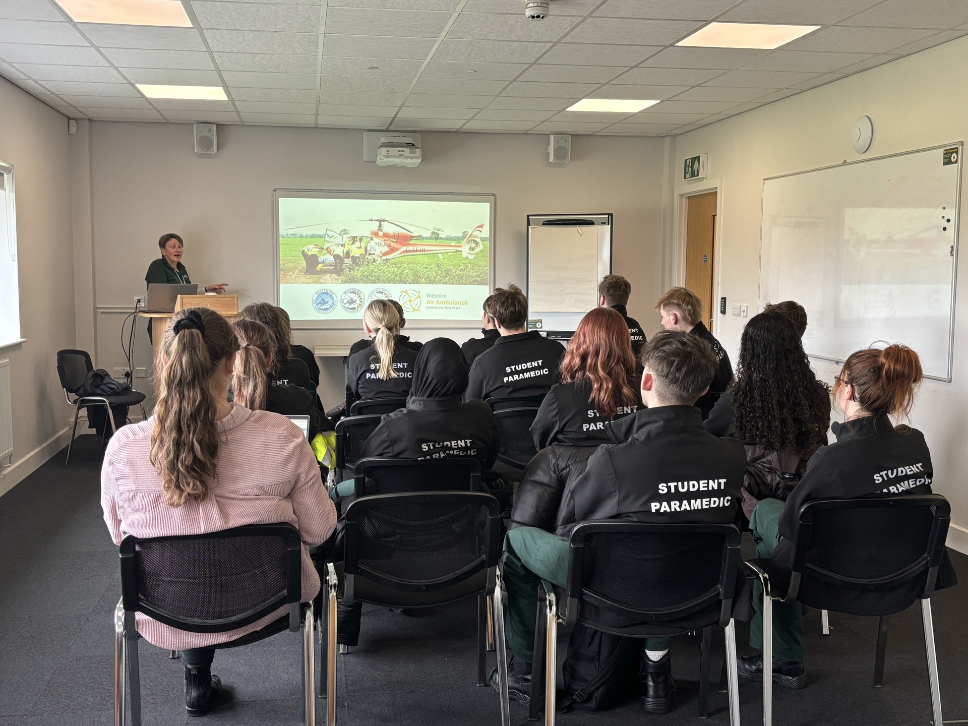 A group of student paramedics sat in seats, looking at a projection