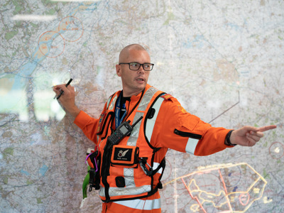 Paramedic Paul Rock standing in front of large map in Wiltshire Air Ambulance's Ops room Paramedic Paul Rock standing in front of large map in Wiltshire Air Ambulance's Ops room