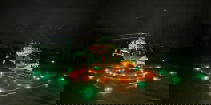 Wiltshire and Bath Air Ambulance Charity's new look helicopter on their helipad at night with the lights on