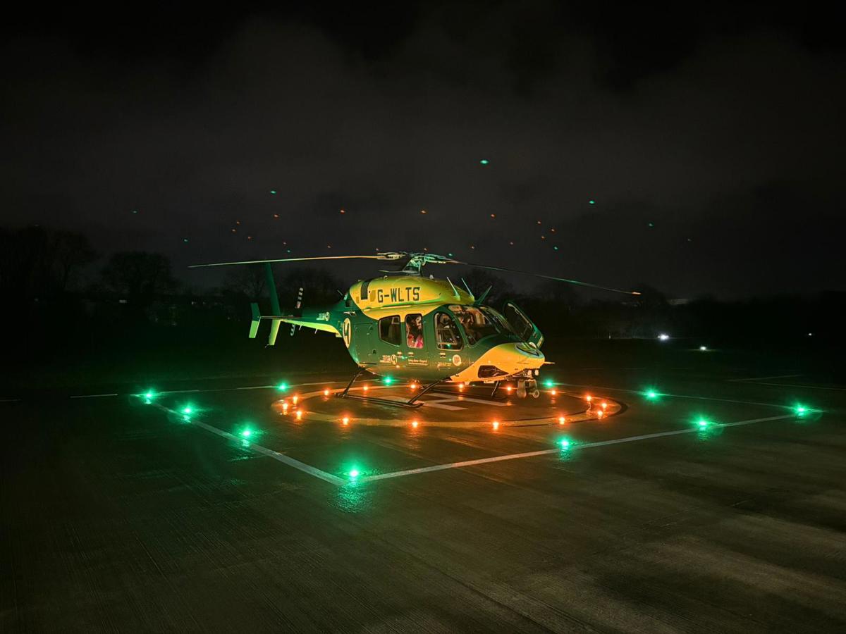 Wiltshire and Bath Air Ambulance Charity's new look helicopter on their helipad at night with the lights on Wiltshire and Bath Air Ambulance Charity's new look helicopter on their helipad at night with the lights on
