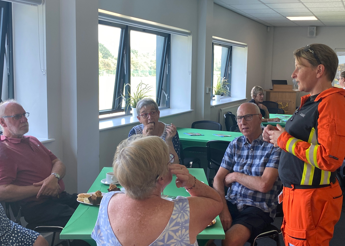 A paramedic, wearing an orange flight suit, talking to WAA supporters A paramedic, wearing an orange flight suit, talking to WAA supporters