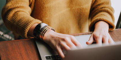 A person typing on a laptop and the option to find out more information about getting your will for free online